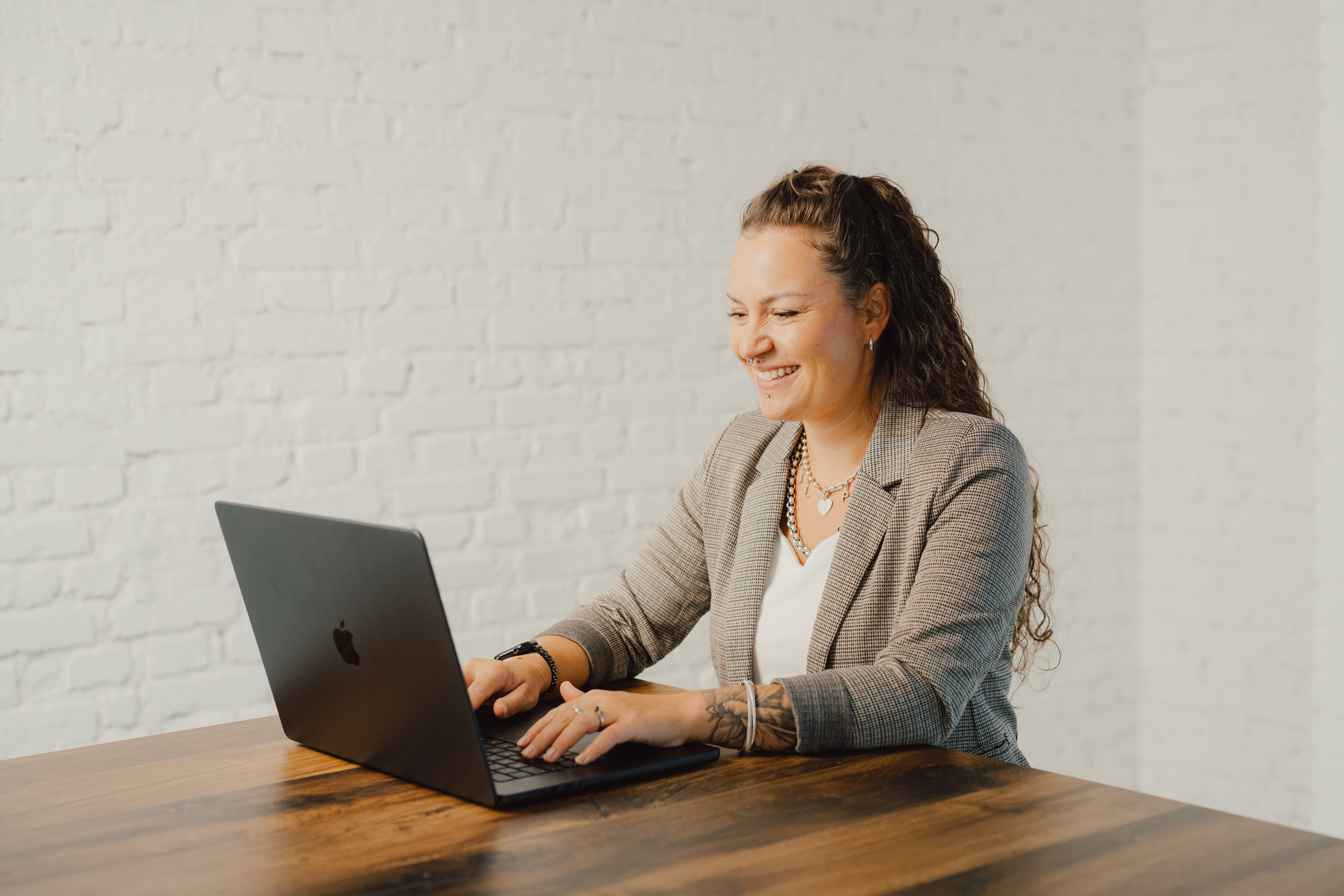 Kim-Nina Ernst arbeitet am Laptop an einem Holztisch